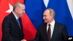 FILE - Russian President Vladimir Putin, right, and Turkish President Recep Tayyip Erdogan shake hands during a news conference after their talks in the Kremlin, in Moscow, Russia, March 5, 2020. 