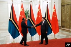 资料照：2019年5月28日，中国国家主席习近平在人民大会堂与瓦努阿图总理萨尔维(左)握手