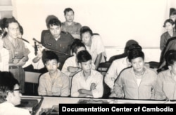 FILE - Chhang Song, assistant to Lon Nol’s spokesperson Am Rong who spoke in a press conference, stood to the right with a logo on his left sleeve. Chhang Song was later appointed Minister of Information of the Khmer Republic. The young men sitting in the front row are Viet Cong’s soldiers captured from the battle fields. (Documentation Center of Cambodia Archives/The Lon Nol Dossier)