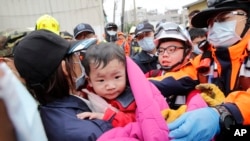 Bayi laki-laki diselamatkan dari gedung yang runtuh akibat gempa bumi di Tainan, Taiwan, 6 Februari 2016. 