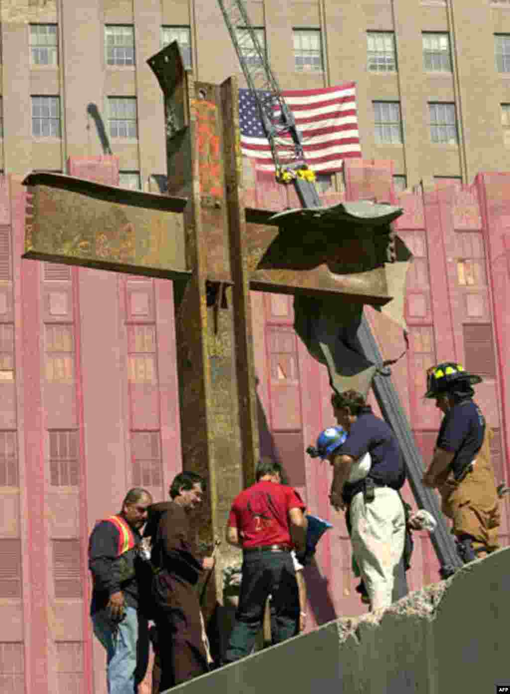 Father Brian Jordan, second from left, blesses, Thursday, Oct. 4, 2001, a cross of steel beams found amidst the rubble of the World Trade Center by a laborer two days after the collapse of the twin towers. The cross was from World Trade tower One, and w