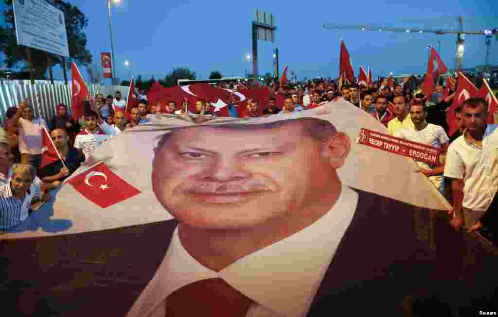 حامیان حکومت ترکیه در جریان یک راهپیمایی که تصویر رئیس جمهور ترکیه، رجب طیب اردوغان را حمل می کنند.