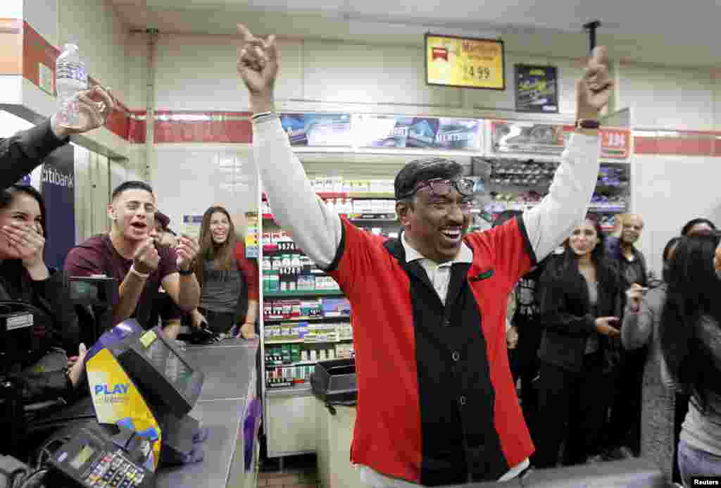7-Eleven store clerk M. Faroqui celebrates after learning that his store sold a winning Powerball ticket, in Chino Hills, California, Jan. 13, 2016.