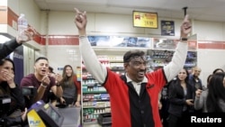 Pegawai toko 7-Eleven, M. Faroqui bersorak ketika mengetahui tokonya menjual tiket lotere Powerball yang menang di kota Chino Hills, California 13 Januari 2016. 