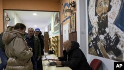 People wait in line during a parliamentary election at a polling station in the northern Serb-dominated part of ethnically divided town of Mitrovica, Kosovo, Feb. 9, 2025.