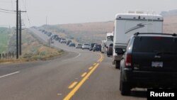 A police escorted convoy of residents of the town of Cache Creek are pictured on Highway 1 near Savona, British Columbia, Canada, July 18, 2017. 
