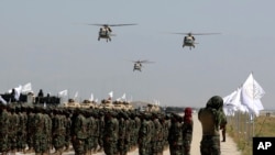 FILE - UH-60 Black Hawk helicopters fly during a military parade to mark the third anniversary of the withdrawal of U.S.-led troops from Afghanistan, in Bagram Air Base in the Parwan Province of Afghanistan, Aug. 14, 2024. 