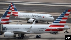 This July 17, 2019 photo shows American Airlines planes at Phoenix Sky Harbor International Airport in Phoenix. 
