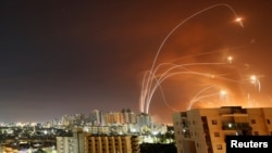 Trayectorias de misiles lanzados desde la Franja de Gaza e interceptados por sistemas de defensa israelíes iluminan el cielo en Ashkelon, Israel, el 12 de mayo de 2021.