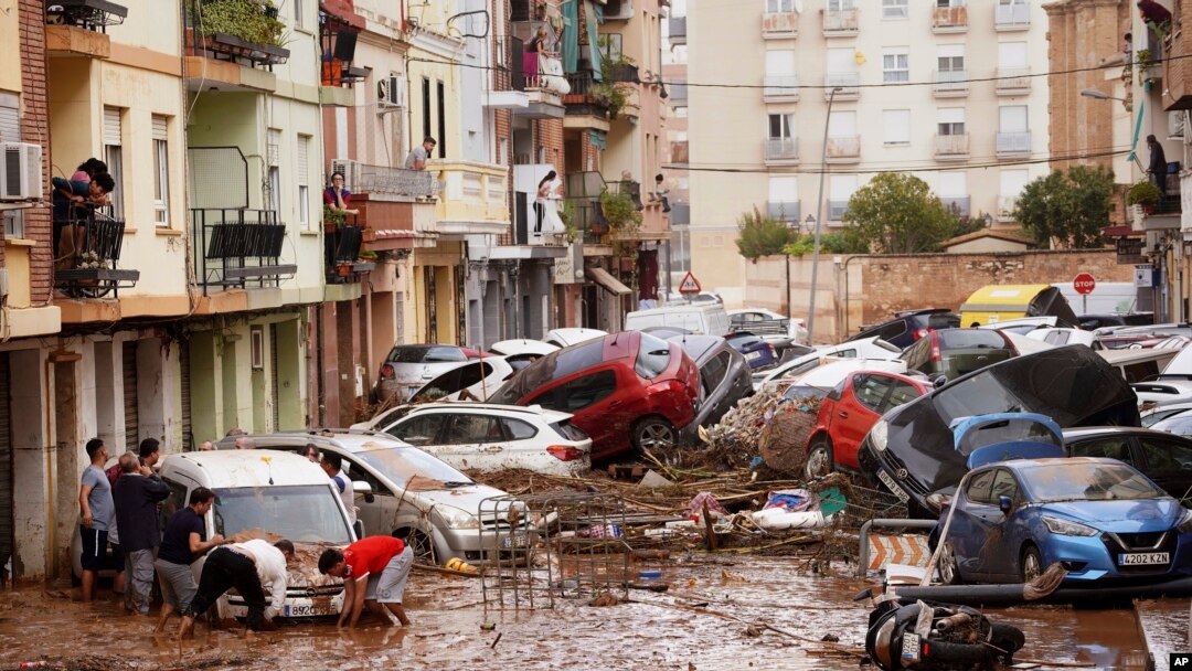 Los residentes observan los autos amontonados luego de ser arrastrados por las inundaciones en Valencia, España, el miércoles 30 de octubre de 2024. (Foto AP/Alberto Saíz).