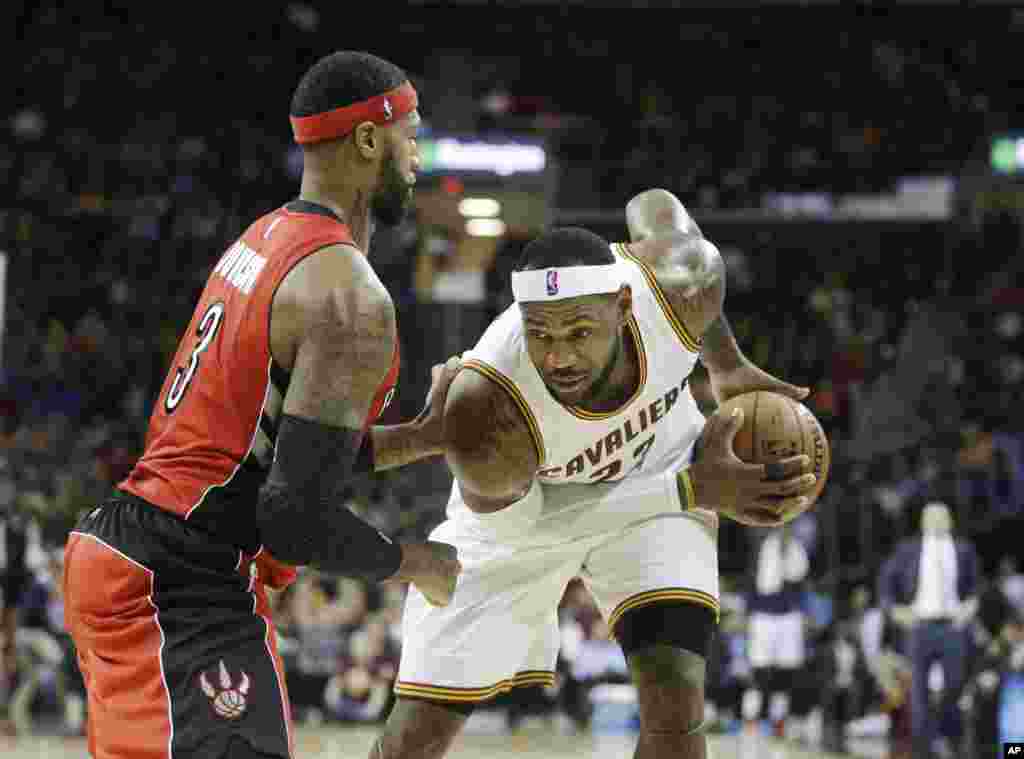 LeBron James des Cavaliers de Cleveland à droite, en position d&rsquo;attaque lors de&nbsp;la rencontre face aux Raptors de Toronto. Cleveland0, 9 décembre 2014