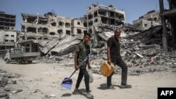 Palestinci prolaze pored srušenih zgrada u Kan Junisu na jugu Pojasa Gaze (Foto: AFP)