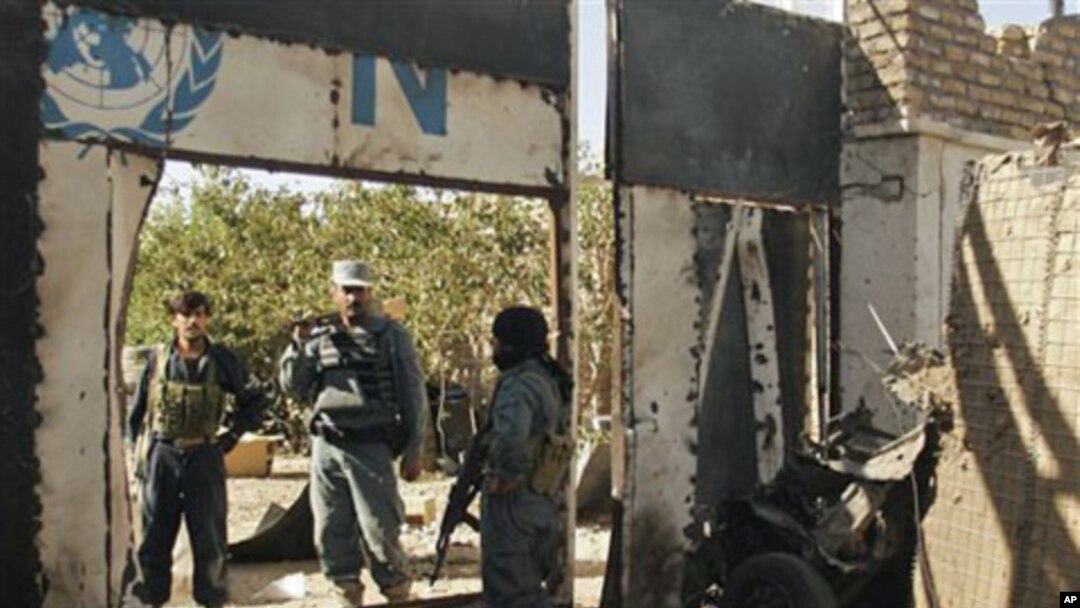 Afghan security forces secure an entrance next to the wreckage of a suicide bomber's vehicle at a UN compound in Herat, west of Kabul, Afghanistan, 23 Oct 2010