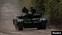Prajurit Ukraina menaiki sebuah tank di jalan menuju kota garis depan Bakhmut, di tengah serangan Rusia di Ukraina, di wilayah Donetsk, Ukraina Jumat 12 Mei 2023.