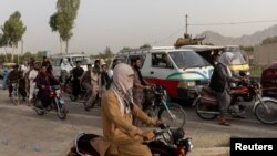 Traffic is stopped as members of Afghan Special Forces regroup after heavy clashes with the Taliban, at a checkpoint in Kandahar province, Afghanistan, July 13, 2021.
