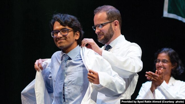 Syed Rakin Ahmed receives his white coat during a medical school ceremony.