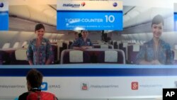 Seorang penumpang tengah memeriksa informasi di tempat penjualan tiket pesawat Malaysia Airways di Bandara Internasional Kuala Lumpur di Sepang, luar Kuala Lumpur (8/3).