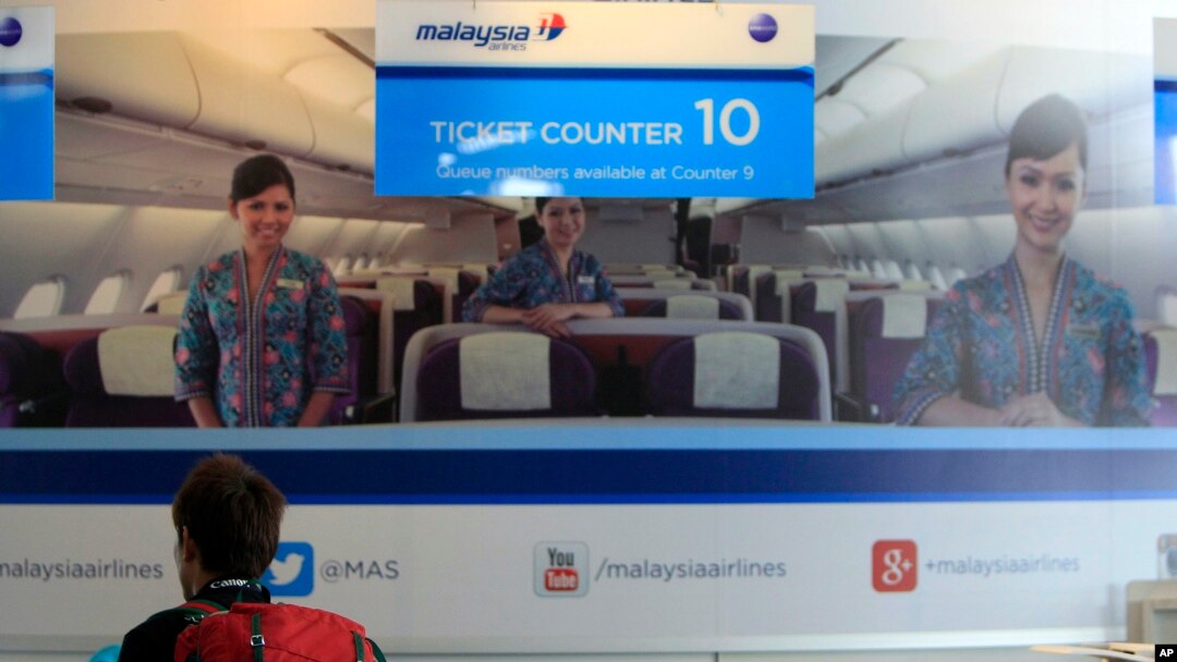 Seorang penumpang tengah memeriksa informasi di tempat penjualan tiket pesawat Malaysia Airways di Bandara Internasional Kuala Lumpur di Sepang, luar Kuala Lumpur (8/3).