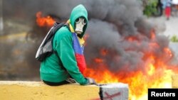 Un manifestante descansa frente a una barricada en una calle de Caracas en donde siguen multiplicándose las protestas contra el gobierno.