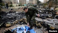FILE - A Russian soldier checks a burned medical tent after rebels launched a mortar shell at a field hospital in west Aleppo, Syria, Dec. 5, 2016. 