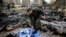 FILE - A Russian soldier checks a burned medical tent after rebels launched a mortar shell at a field hospital in west Aleppo, Syria, Dec. 5, 2016. 