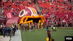 Fans await the entrance of the Washington Redskins through a large, inflatable helmet, as the Washington Redskins host the Jacksonville Jaguars, at FedEx Stadium in Landover, Maryland, Sept. 14, 2014. (VOA / Frank Mitchell)
