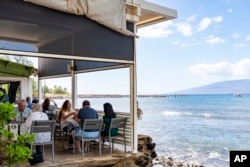 Guests enjoy their lunch at Mala Ocean Tavern in Lahaina on the island of Maui in Hawaii, Nov. 18, 2024. Mala Ocean Tavern is the first restaurant on Front Street to reopen after last year's wildfire.