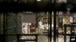 FILE - A detainee walks through a communal pod inside an area of the Guantanamo Bay detention center known as Camp 6, at Guantanamo Bay U.S. Naval Base, Cuba, June 7, 2014.