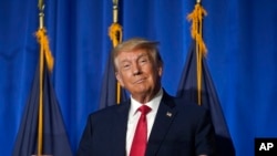 ARCHIVO - El expresidente Donald Trump hace un gesto antes de acercarse a un micrófono para dirigirse a una audiencia en el Almuerzo Lila de la Federación de Mujeres Republicanas de New Hampshire, el martes 27 de junio de 2023, en Concord, EEUU.