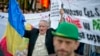 Romania Canada Gold Mine Protest: FILE -A man holding a banner that reads "Stop the Rosia Montana siege" shouts during a protest in Bucharest, Romania, in this Sunday, Sept. 22, 2013 file photo.