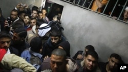 Palestinians gather as the body of Abdullah Mohana, Islamic Jihad militant, is brought to the morgue of the Nasser hospital in Khan Younis, southern Gaza Strip, Saturday, Nov. 5, 2011.