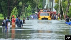 Sebuah truk membawa orang-orang melewati jalanan yang terkena banjir di Thrissur, Kerala, India, 18 Agustus 2018.