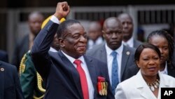 Emmerson Mnangagwa, center, and his wife Auxillia, right, arrive at the presidential inauguration ceremony in Harare, Zimbabwe, Nov. 24, 2017. 