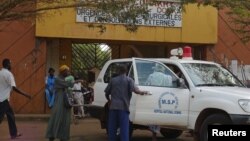 People walk in front of the entrance of Donka Hospital, where victims of the ebola disease are being treated, in Conakry.