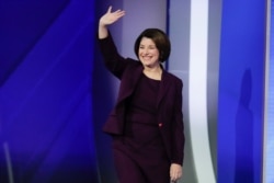 Sen. Amy Klobuchar, D-Minn., waves on stage, Feb. 7, 2020, before the start of a Democratic presidential primary debate hosted by ABC News, Apple News, and WMUR-TV at Saint Anselm College in Manchester, N.H.