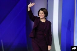 Sen. Amy Klobuchar, D-Minn., waves on stage, Feb. 7, 2020, before the start of a Democratic presidential primary debate hosted by ABC News, Apple News, and WMUR-TV at Saint Anselm College in Manchester, N.H.