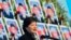 South Korea's President Park Geun-Hye speaks in front of photographs of sailors who died, during an event marking the third anniversary of the sinking of a South Korean naval vessel by what Seoul insists was a North Korean submarine, at the national cemet