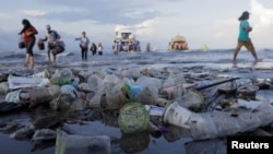 Tourists and local residents disembark a boat coming from nearby Nusa Penida island as plastic trash pollutes the beach in Sanur, Denpasar, Bali, Indonesia April 10, 2018. REUTERS/Johannes P. Christo 