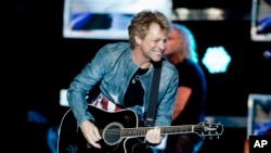FILE - Singer Jon Bon Jovi play the guitar during a concert of the American rock band Bon Jovi in Madrid, Spain, Thursday June 27, 2013. (AP Photo/Abraham Caro Marin)