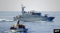 Les supporters tunisiens du Croissant Sportif Chebbien (CSC), qui menacent depuis des semaines d'émigrer en Italie pour protester contre les sanctions contre leur club, embarquent le 12 novembre 2020 sur des bateaux de pêche dans le port méditerranéen.