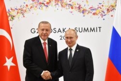 FILE - Russian President Vladimir Putin (R) shakes hands with Turkish President Recep Tayyip Erdogan during their bilateral meeting on the sidelines of the G20 leaders summit in Osaka, Japan, June 29, 2019.