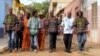 The eight members of Super Mama Djombo, including founder Ze Manel Fortes and composer Atchutchi, walk through the streets of Bissau's old town, Guinea-Bissau, May 2, 2012. (K. Thomas/VOA)