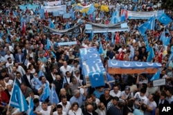 FILE - Uighurs living in Turkey and their supporters, some carrying coffins representing Uighurs who died in China's far-western Xinjiang region, chant slogans as they stage a protest in Istanbul against what they call China's oppression of Muslim Uighurs, July 4, 2015.