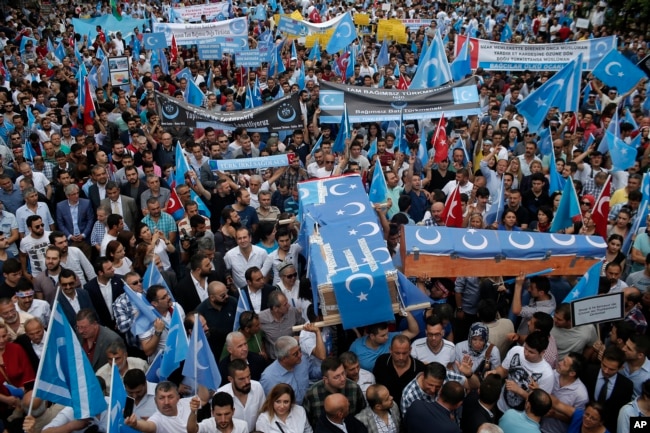 FILE - Uighurs living in Turkey and their supporters, some carrying coffins representing Uighurs who died in China's far-western Xinjiang region, chant slogans as they stage a protest in Istanbul against what they call China's oppression of Muslim Uighurs, July 4, 2015.