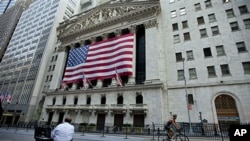 A cyclist rides past the New York Stock Exchange in New York, Aug. 5, 2011
