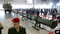 Russian military officers stand by as the 9M729, center, its launcher, left, and the 9M728, right, land-based cruise missiles are displayed in Kubinka outside Moscow, Russia, Jan. 23, 2019.