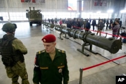 Russian military officers stand by as the 9M729, center, its launcher, left, and the 9M728, right, land-based cruise missiles are displayed in Kubinka outside Moscow, Jan. 23, 2019.