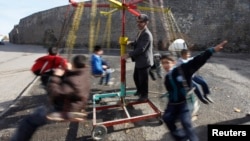 FILE - Turkish children are seen playing on a make-shift carousel.
