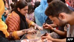Des femmes se font appliquées du henné à Lahore, le 14 juin 2018.