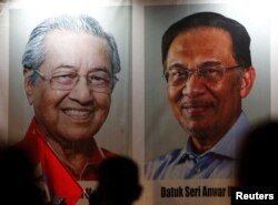 Poster Perdana Menteri Malaysia Mahathir Mohammad dan politisi Anwar Ibrahim, yang diberikan pengampunan kerajaan, di Kuala Lumpur, Malaysia 16 Mei 2018. (Foto: REUTERS/Lai Seng Sin)